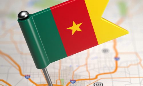 Small Flag of Cameroon on a Map Background with Selective Focus.